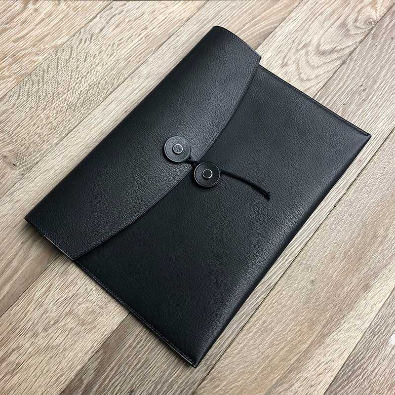 the tether pouch in black leather displayed on a wooden surface