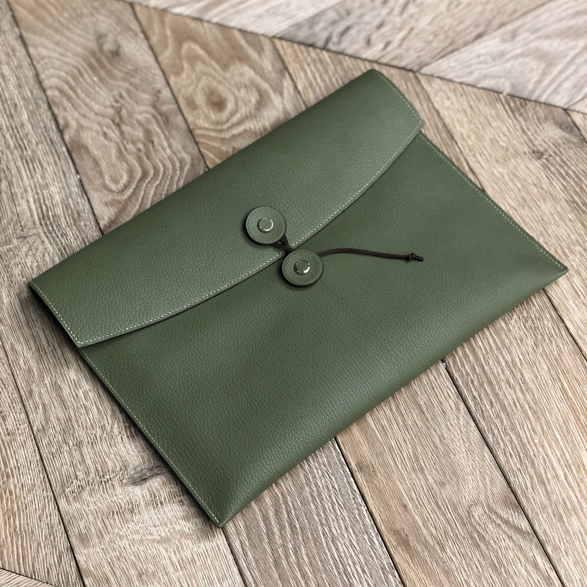 the tether pouch in green laid on a wooden surface