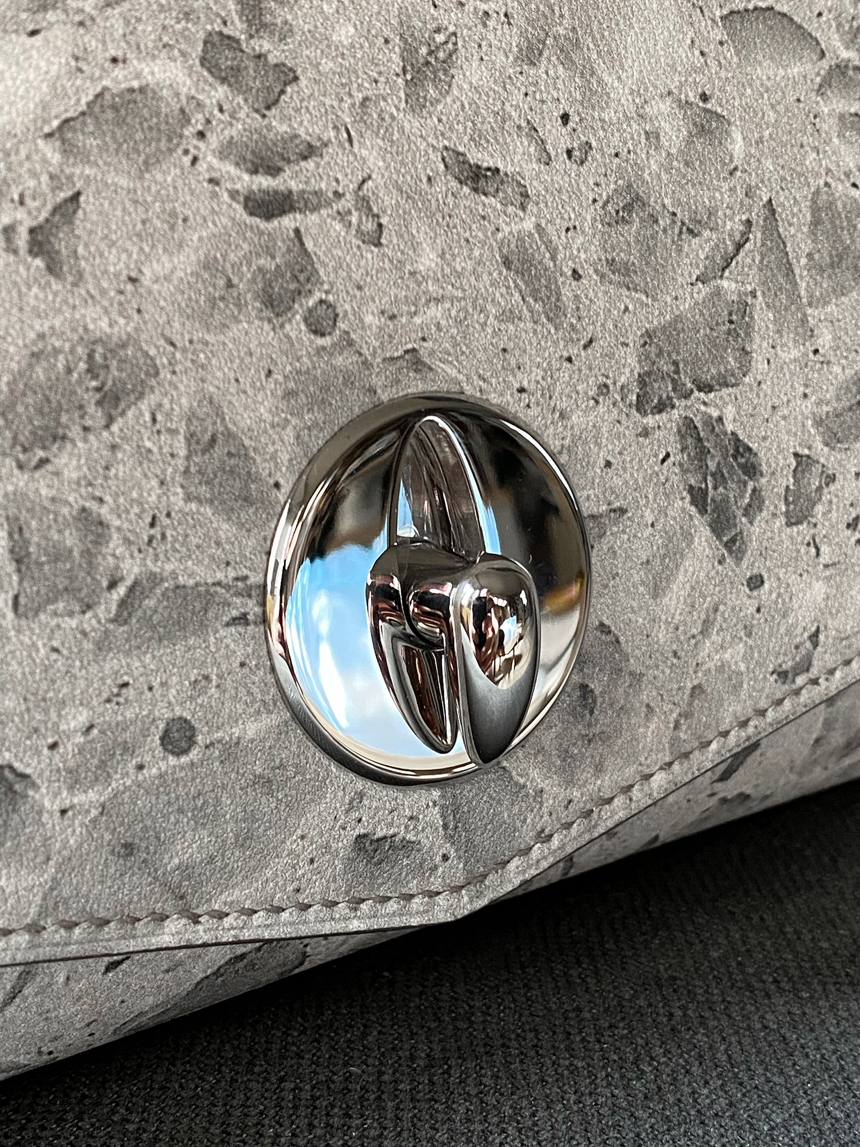 the silver hardware closure of the lorin flap bag